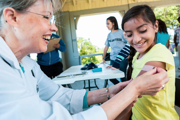 Pediatric doctor in a fellowship program providing free vaccines in a community initiative