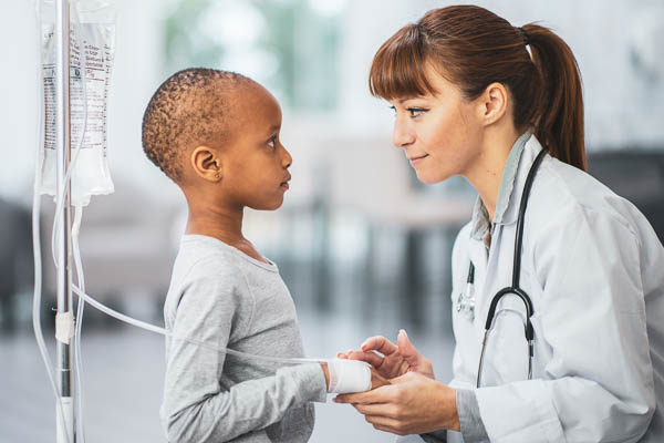 Pediatric doctor in a fellowship program comforting a pediatric leukemia patient
