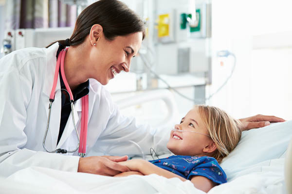 A resident pediatric doctor tending to a pediatric patient